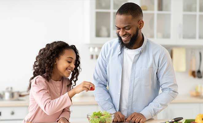 CMS ALT TEXT A father and daughter prepare a meal together in their kitchen.