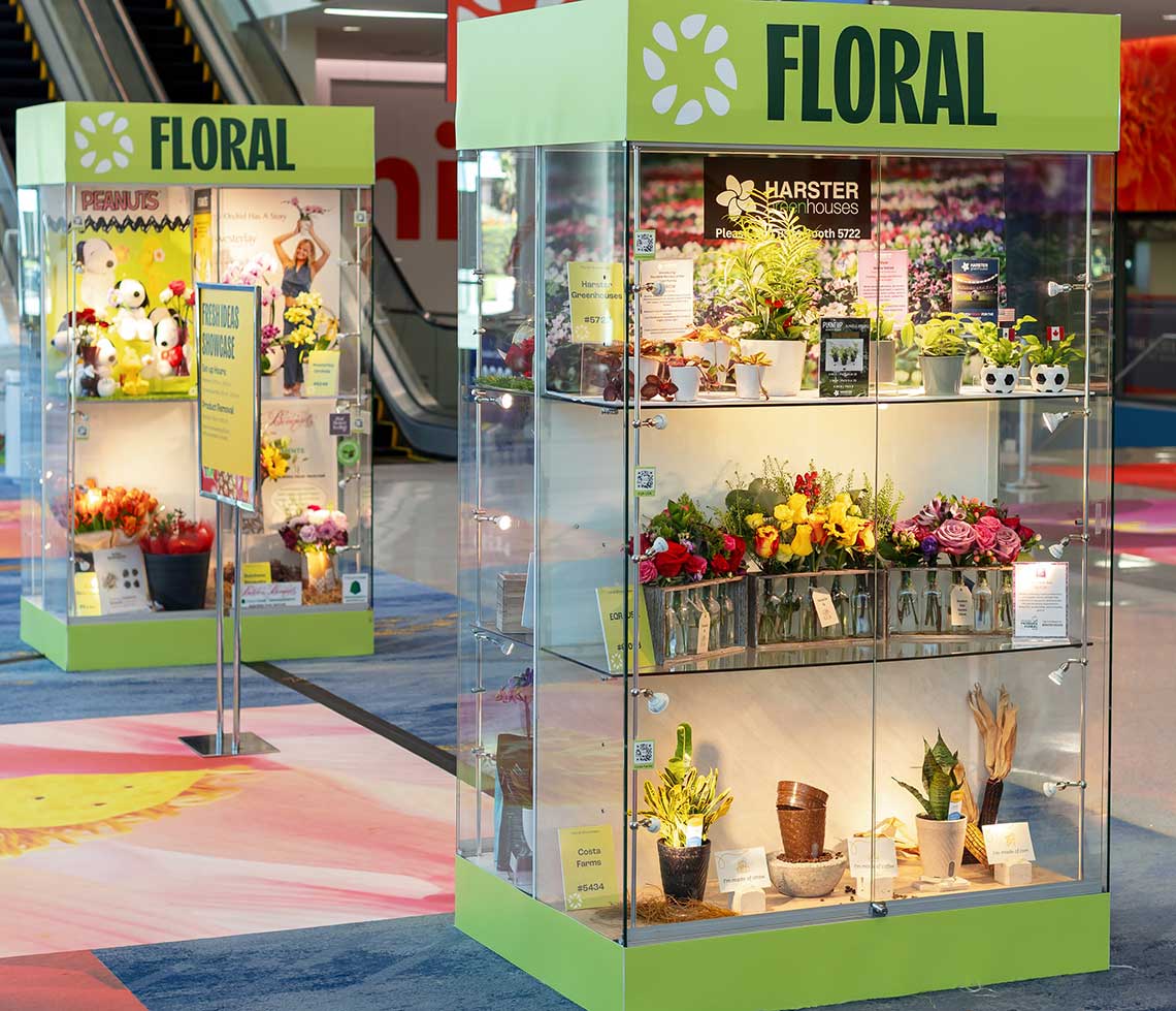 Two display cases labeled "FLORAL" showcasing various plants and flowers inside a well-lit indoor space.