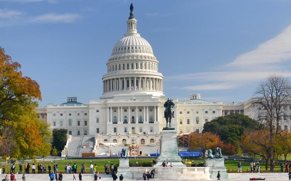 The front of the US Capitol Building in Autumn with visitors walking around