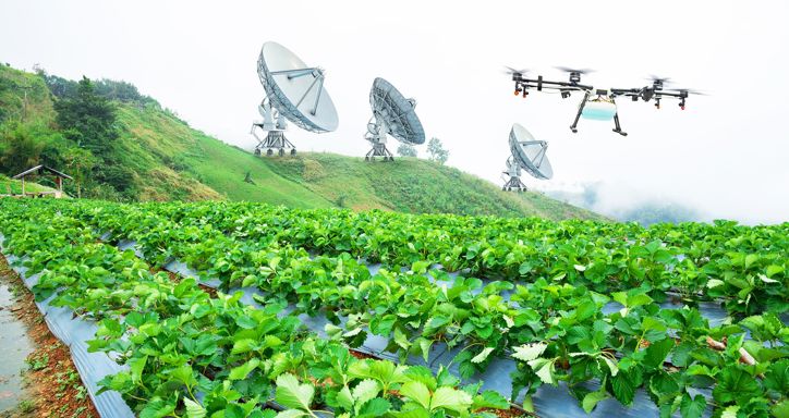 Rolling hills of green crops with big satellite dishes in the background and a drone flying overhead.